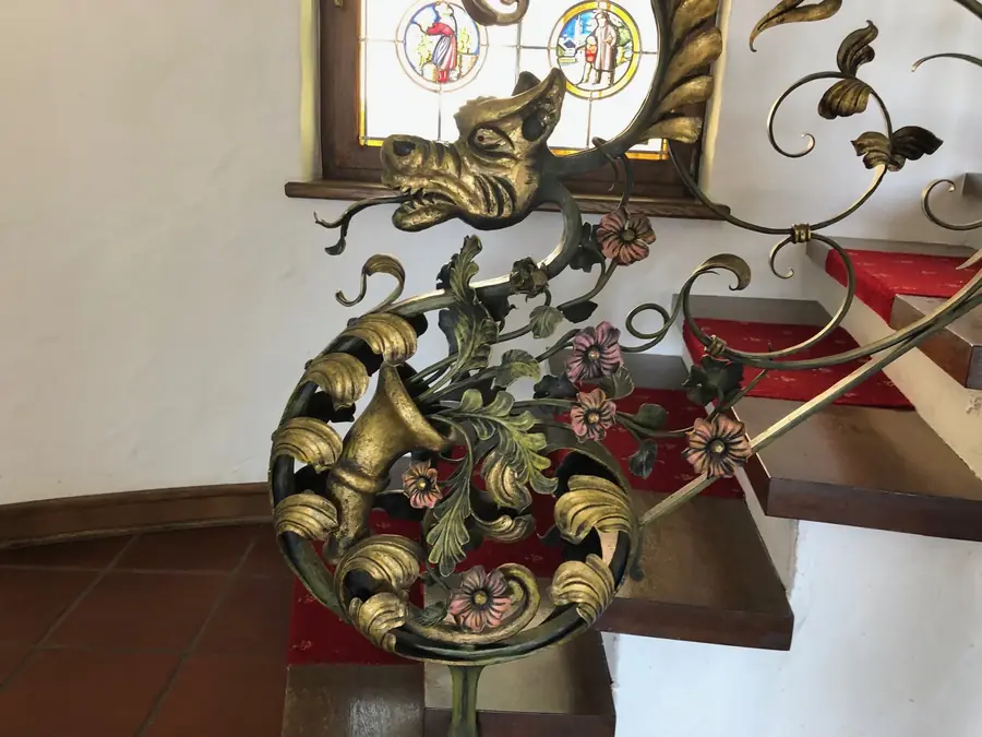 Schmiedeeiserner Drachenkopf am Treppengeländer