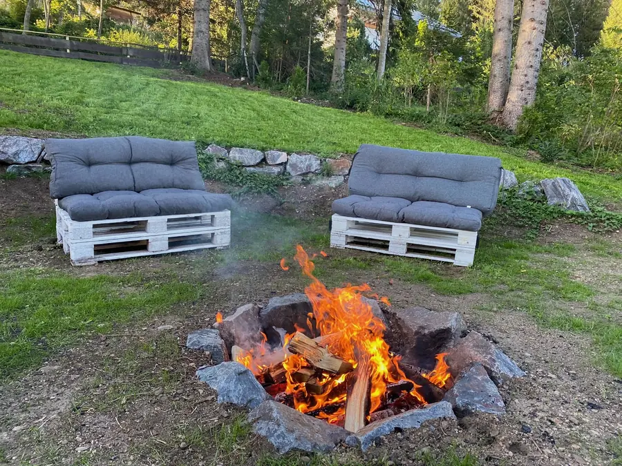 Feuerstelle mit Palettensofas auf der Wiese